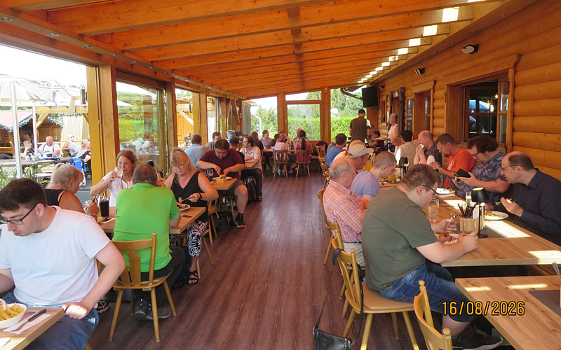 Beim Essen in der Biker Ranch, in einem Raum mit bodentiefen fenstern an 3 Seiten und einer Holzwand