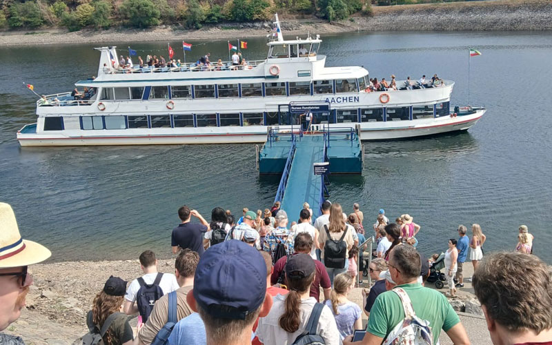 Die Freizeitgruppe wartet darauf, dass das Ausflugsboot am Steg anlegt